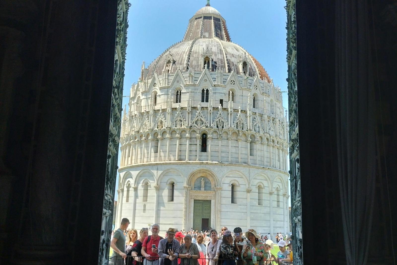 Vue de la Tour de Pise encadrée par des portes