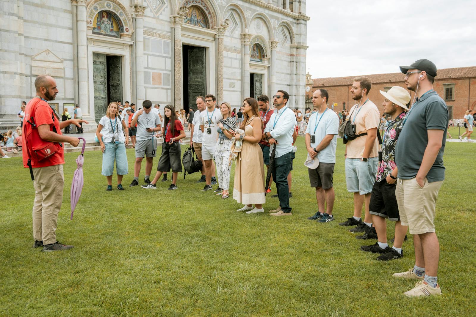 Guida turistica davanti alla Torre di Pisa